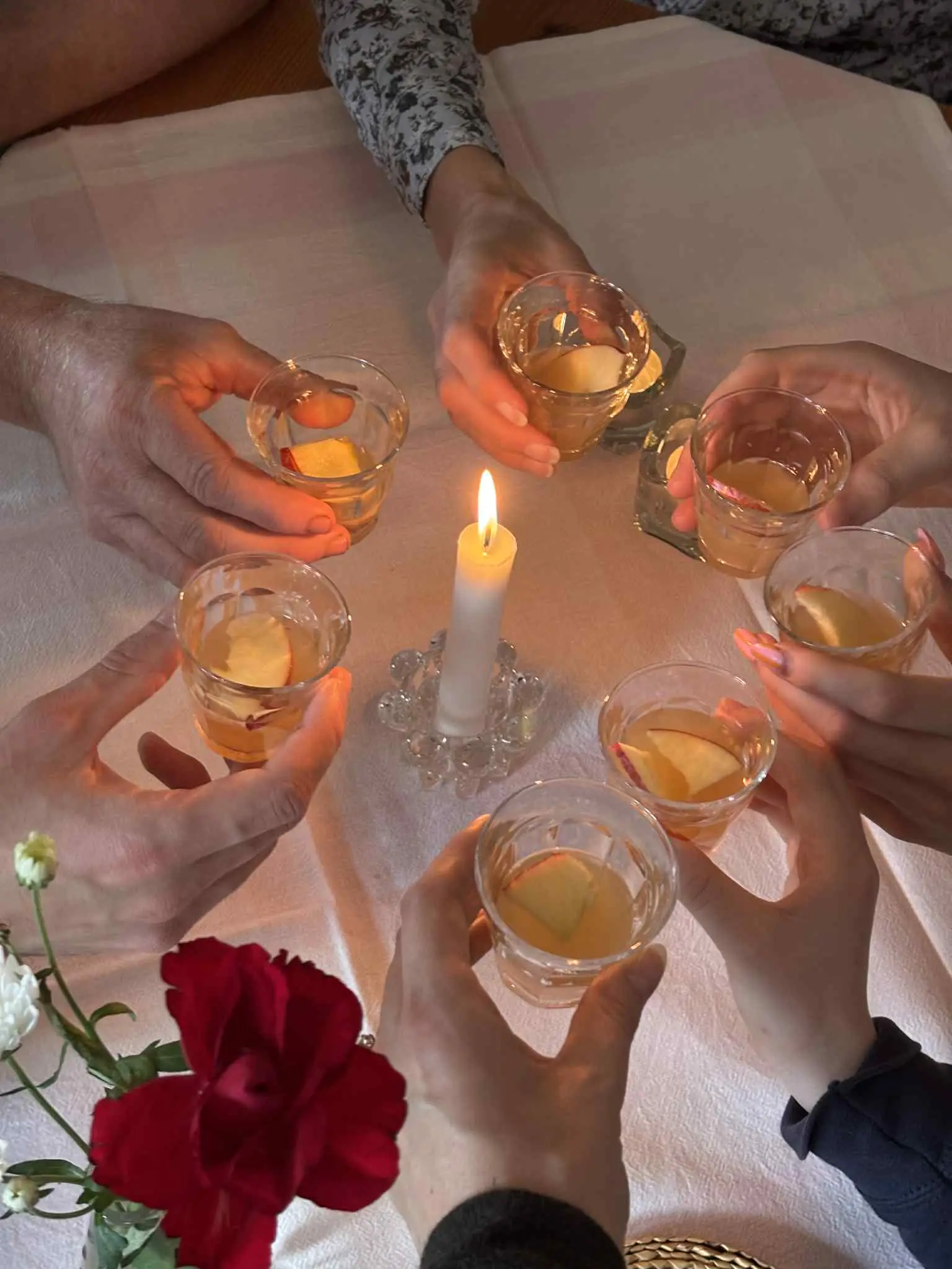 Tända ljus och glas på ett dukat bord