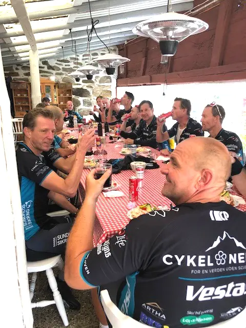 Glad cyklist från Danmark vid långbordet
