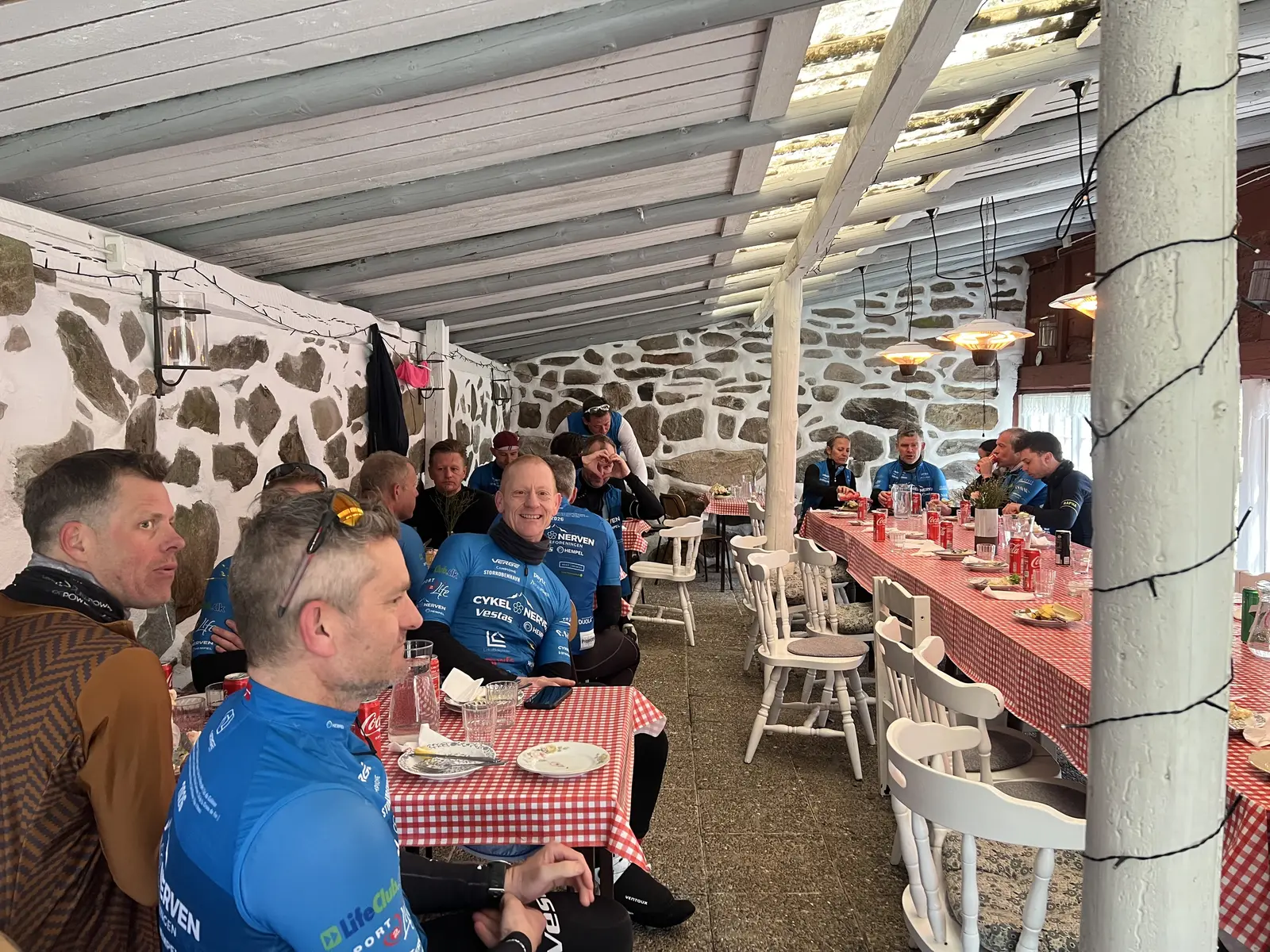 Sällskap i cykelkläder vid ett dukat långbord