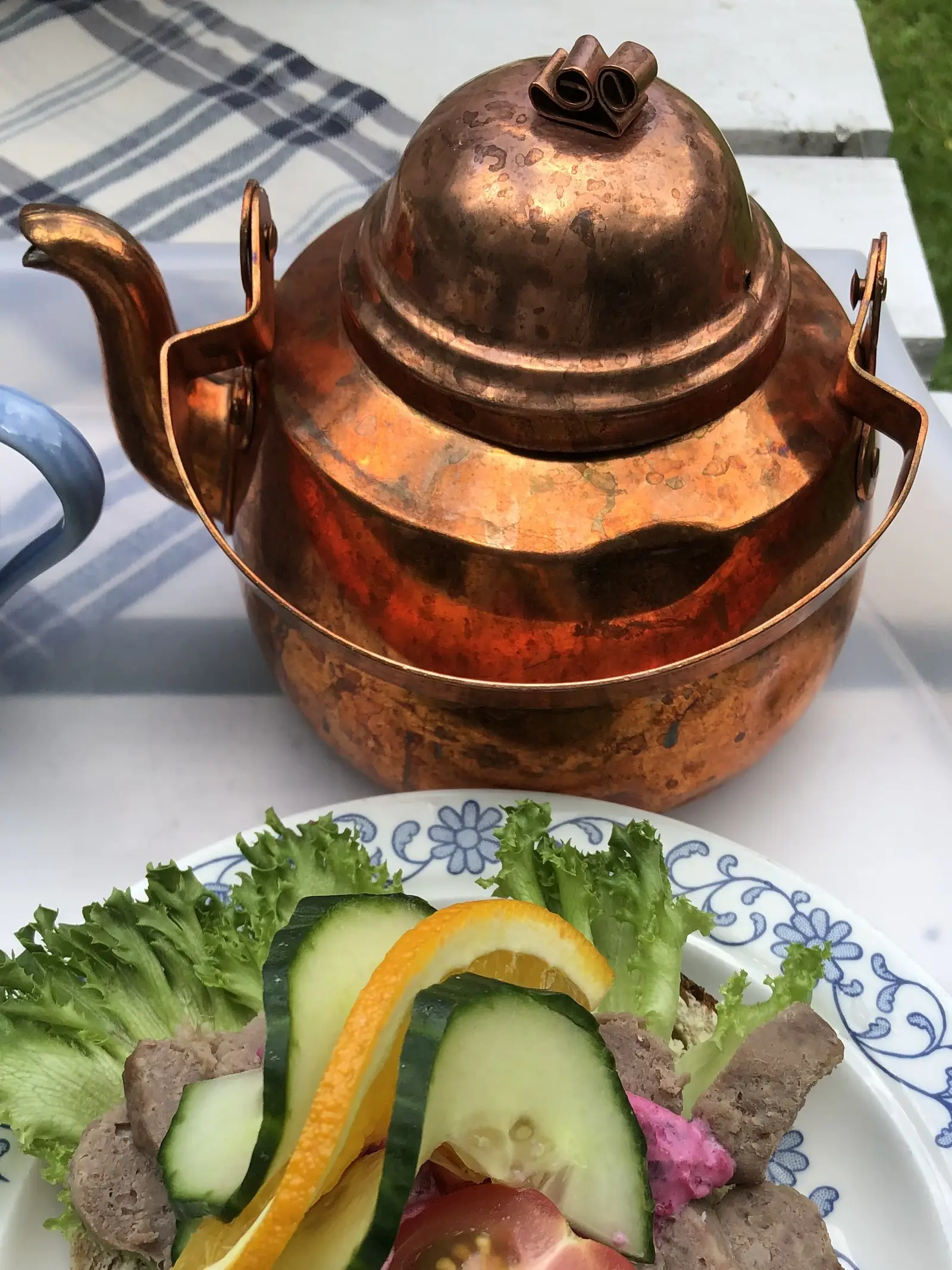 Kopparpanna och smörgås på ett blåmönstrat fat