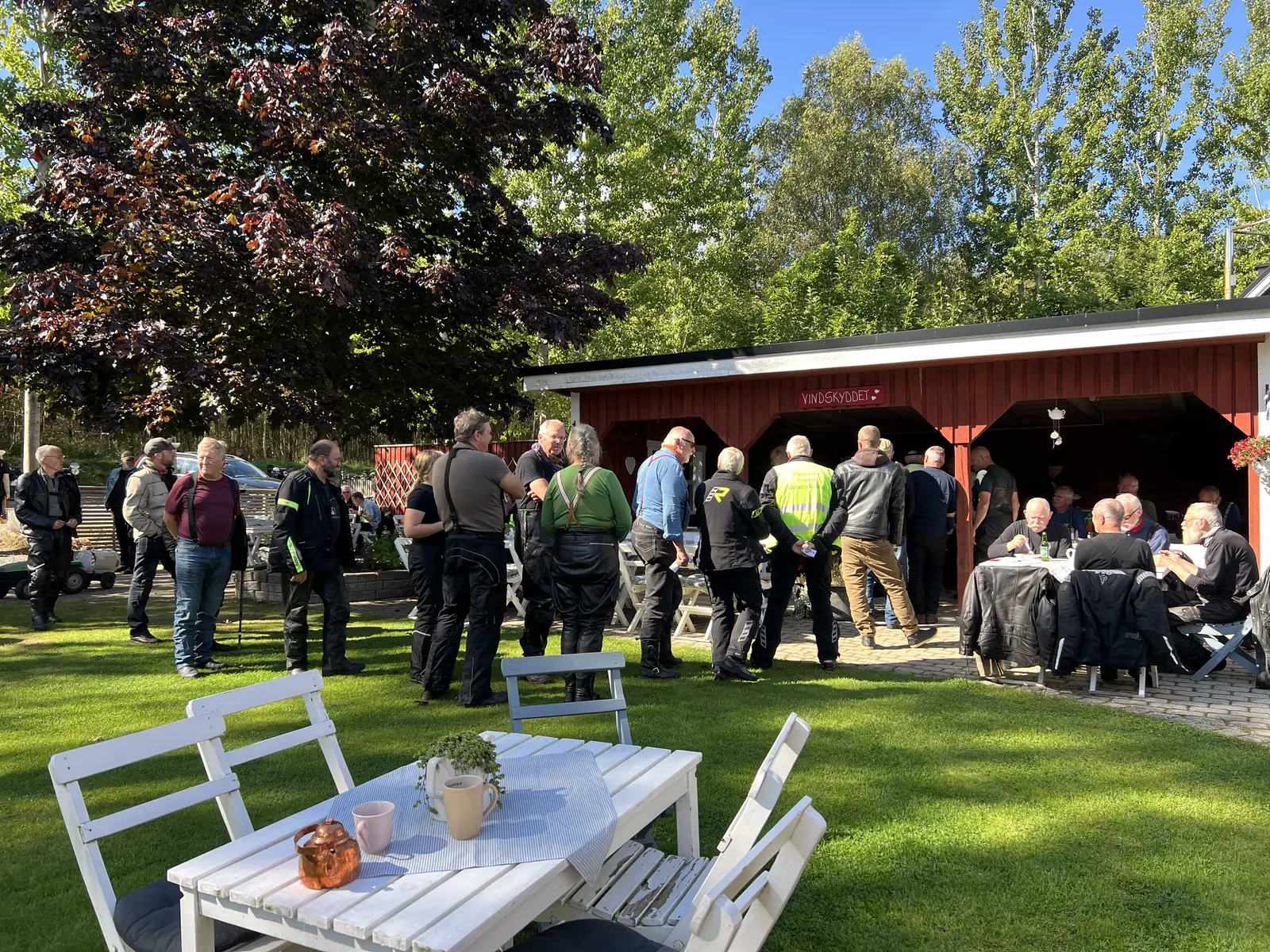 Ett större sällskap samlat i trädgården