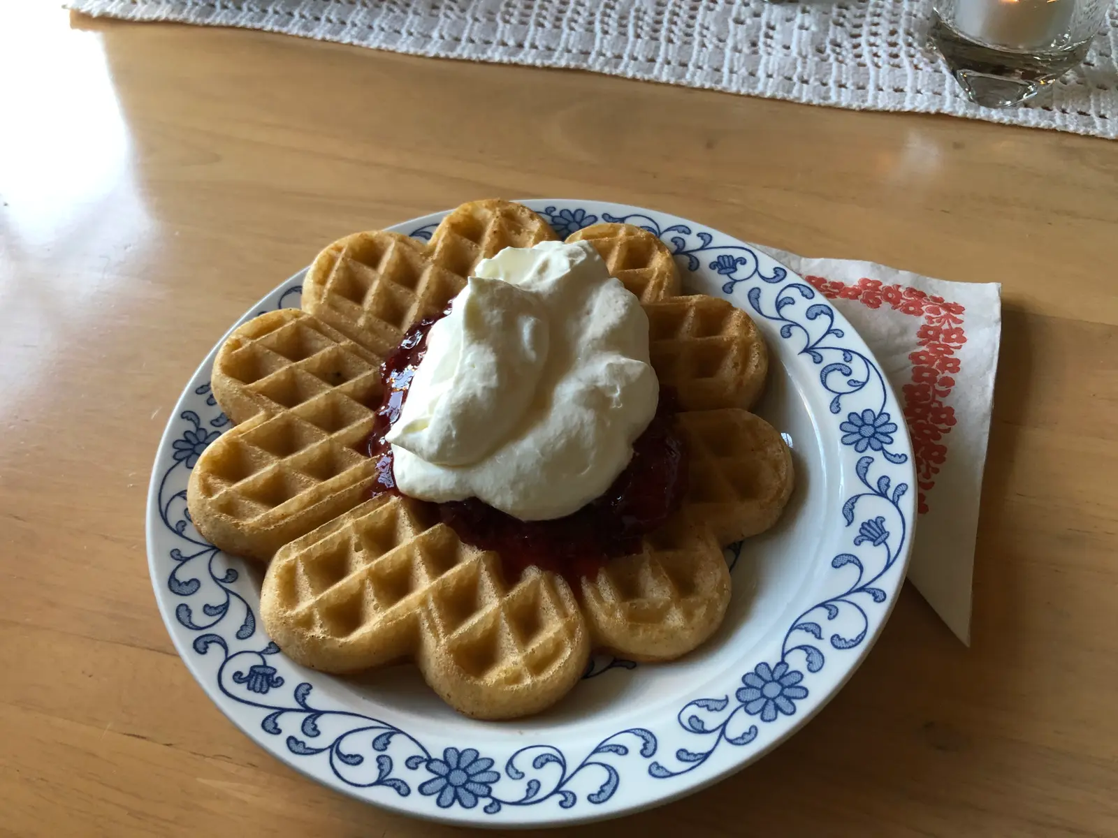 Hjärtvåfflor med sylt och vispad grädde på ett blåmönstrat fat