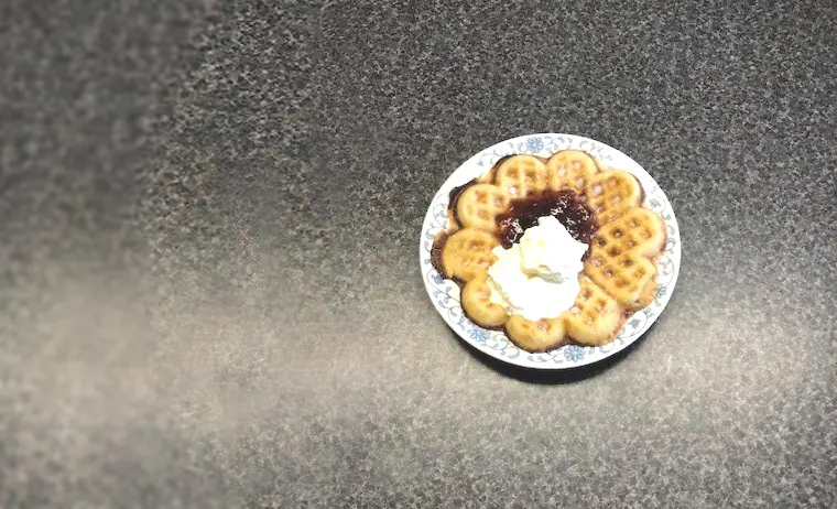 Hjärtvåffla med sylt och grädde på ett blåmönstrat fat